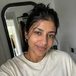 Natural customer-style portrait of a woman wearing a cream oversized T-shirt at home