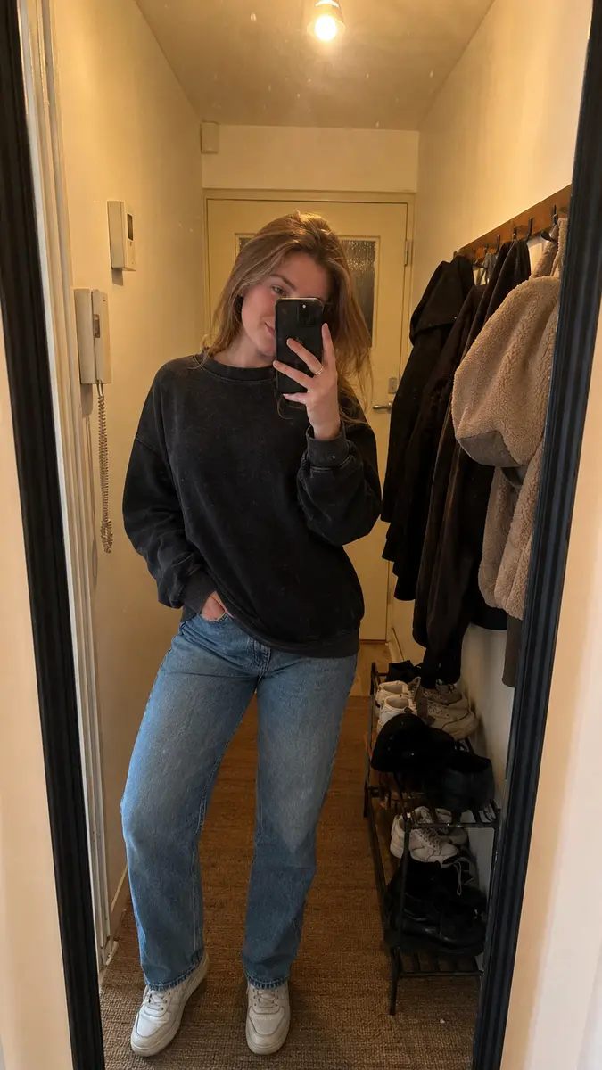 Phone-style hallway mirror photo of a vintage-wash sweatshirt and loose denim